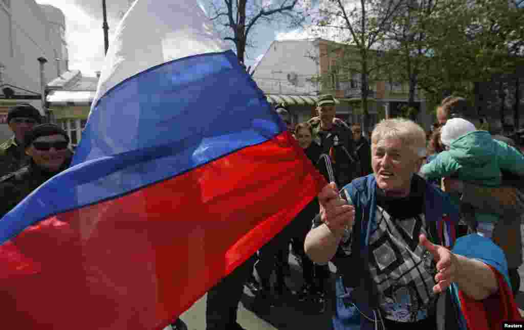 A woman shouts and waves a Russian flag during the celebrations for the 70th anniversary of the liberation of Simferopol from fascist troops during the World War II outside the village of Kurtsy, near Simferopol, Crimea.