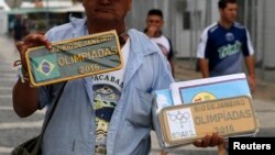 A street vendor offers unauthorized items for sale stamped with Olympic symbols and words along Copacabana beach in Rio de Janeiro, Brazil, July 28, 2016.
