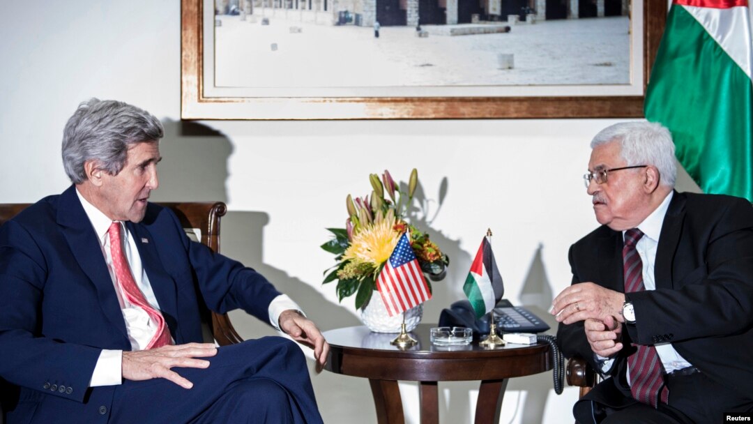 U.S. Secretary of State John Kerry (L) and Palestinian president Mahmoud Abbas talk before a meeting at the presidential compound in the West Bank city of Ramallah on January 3, 2014.