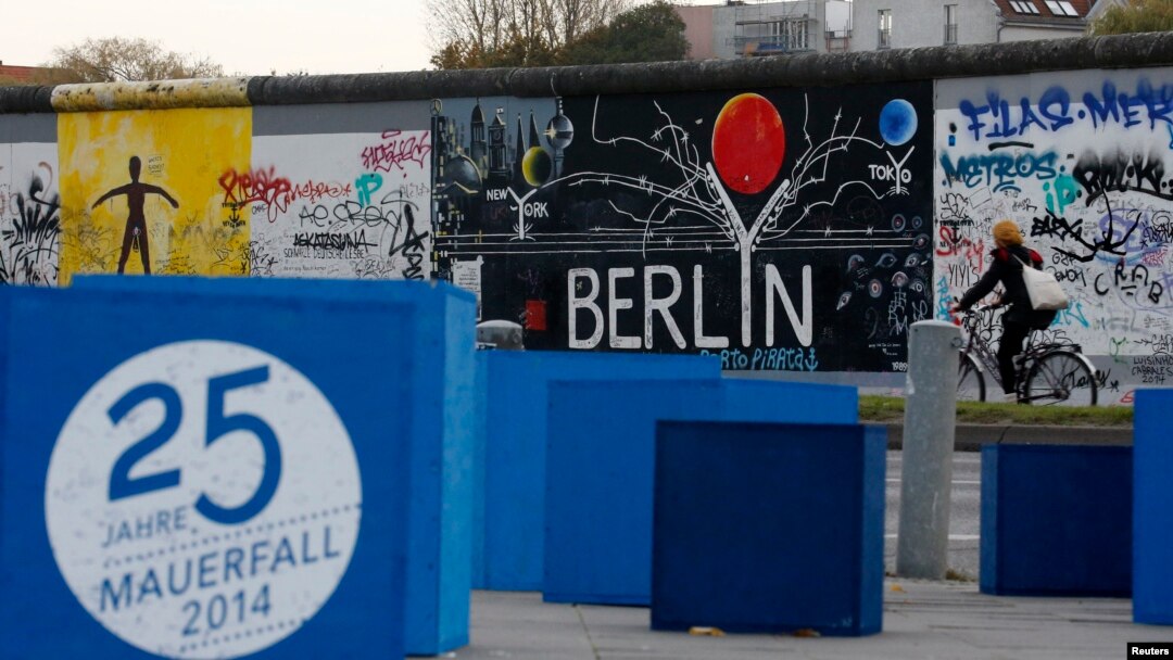 A sign, which reads "25 years Fall of the Wall 2014," is pictured in front of sections at the East Side Gallery, the largest remaining part of the former Berlin Wall in Berlin, Nov. 3, 2014. 