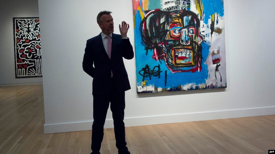 Seorang pejabat Sotheby memberikan keterangan kepada media tentang lukisan "Untitled" karya Jean-Michel Basquiat tahun 1982 di Sotheby's di New York, 5 Mei 2017. (Foto: dok).