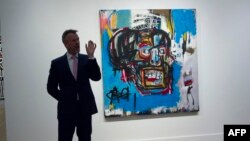 A Sotheby's official speaks about "Untitled," a 1982 painting by Jean-Michel Basquiat during a media preview at Sotheby's in New York, May 5, 2017. The work sold for $110.5 million Thursday in New York, setting a new auction record for the US artist in So