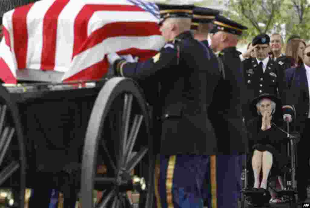 Cecily Flowers, right, watches as a casket holding remains of twelve World War II Army Airmen, including her brother 2nd Lt. William J. Shryock, of Gary, Ind., arrives for burial services at Arlington National Cemetery in Arlington, Va., Thursday, Aug. 4,
