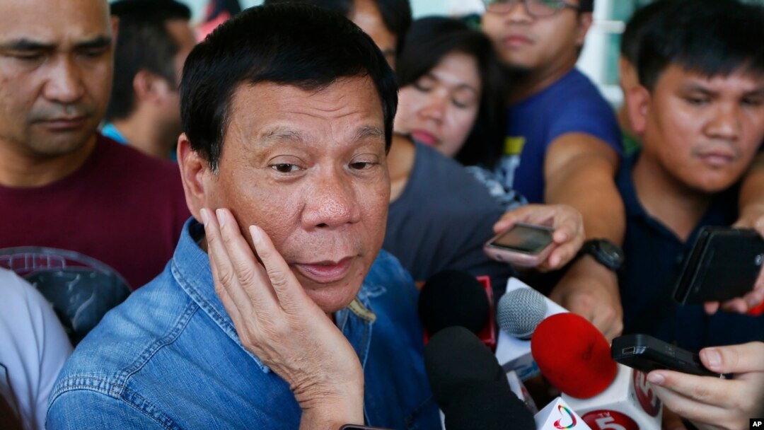 FILE - Philippine presidential candidate Rodrigo Duterte talks to the media before boarding his flight for his hometown of Davao city in southern Philippines.