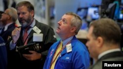 Traders work on the floor of the New York Stock Exchange in New York, Oct. 18, 2018. 