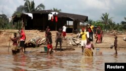 People wash and bathe in a village on the banks of the river Nun in Nigeria's oil state of Bayelsa, Nov. 27, 2012. 