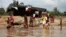 People wash and bathe in a village on the banks of the river Nun in Nigeria's oil state of Bayelsa, Nov. 27, 2012. 