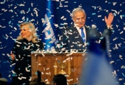 Israeli Prime Minister Benjamin Netanyahu and his wife, Sara, address supporters as confetti falls upon them at the Likud party campaign headquarters in Tel Aviv, March 3, 2020.