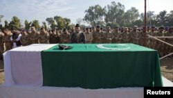 Soldiers stand near the flag-draped casket of their colleague Havildar Ghulam Mohyuddin, whom the Pakistan military said was killed by Indian soldiers while manning a post on the Line of Control (LoC) in the disputed region of Kashmir, during funeral prayers at a garrison mosque in Jhelum, January 11, 2013. 