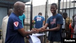 Cassius Kollie (kanan), 24 tahun, dinyatakan sembuh dan dipulangkan dari pusat perawatan ebola di Paynesville, Liberia (foto: dok).