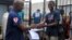 FILE - Cassius Kollie (R), 24, discharged from an Ebola treatment unit, receives a certificate for being cured of the disease in Paynesville, Liberia, July 20, 2015. 