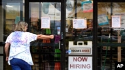 FILE - A hiring sign is displayed outside a retail store in Buffalo Grove, Illinois, June 24, 2021. 