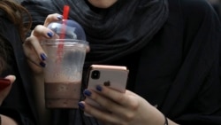 In this Tuesday, July 2, 2019 photo, an Iranian woman works on her cell phone. Before Iranians can check out the latest offerings on Twitter or YouTube, they must search for the best workaround to bypass official censors. 