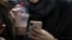 In this Tuesday, July 2, 2019 photo, an Iranian woman works on her cell phone. Before Iranians can check out the latest offerings on Twitter or YouTube, they must search for the best workaround to bypass official censors. 
