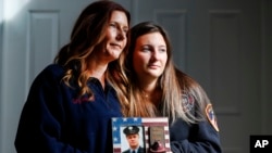 Pamela Yarosz and her daughter Capri are shown with a photo of New York firefighter Christopher Michael Mozzillo, Sept. 7, 2024, in Freehold, N.J.. Mozzillo, who died in the 9/11 attacks, was Pamela's brother. 