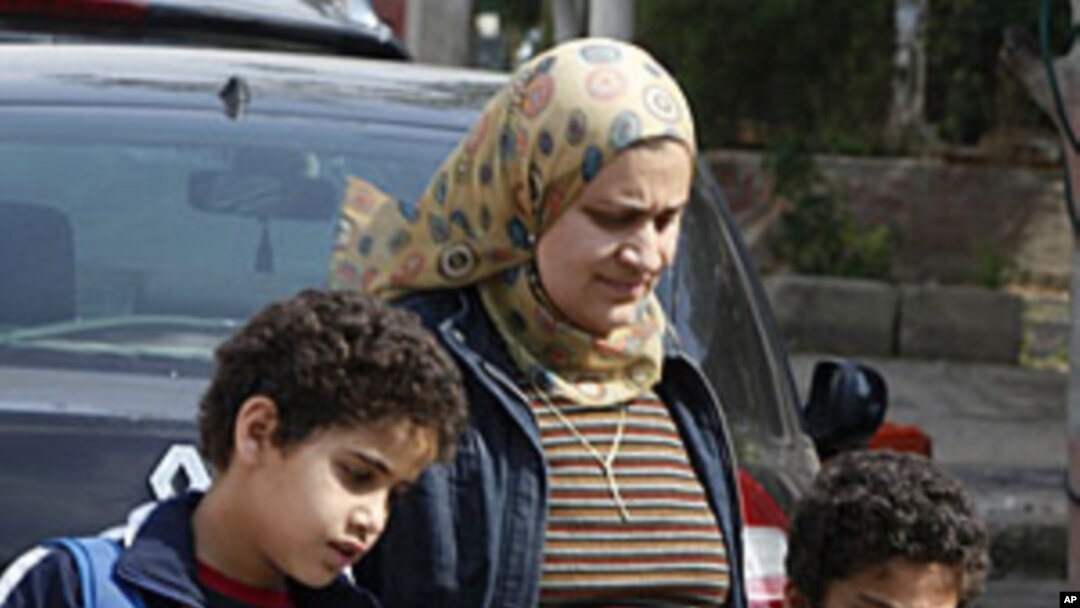 An Egyptian mother collects her sons outside a school in Cairo, April 4, 2011. During the recent mass uprising, as much as fifty percent of police disappeared from cities and their withdrawal has created a security vacuum, letting crime flourish.