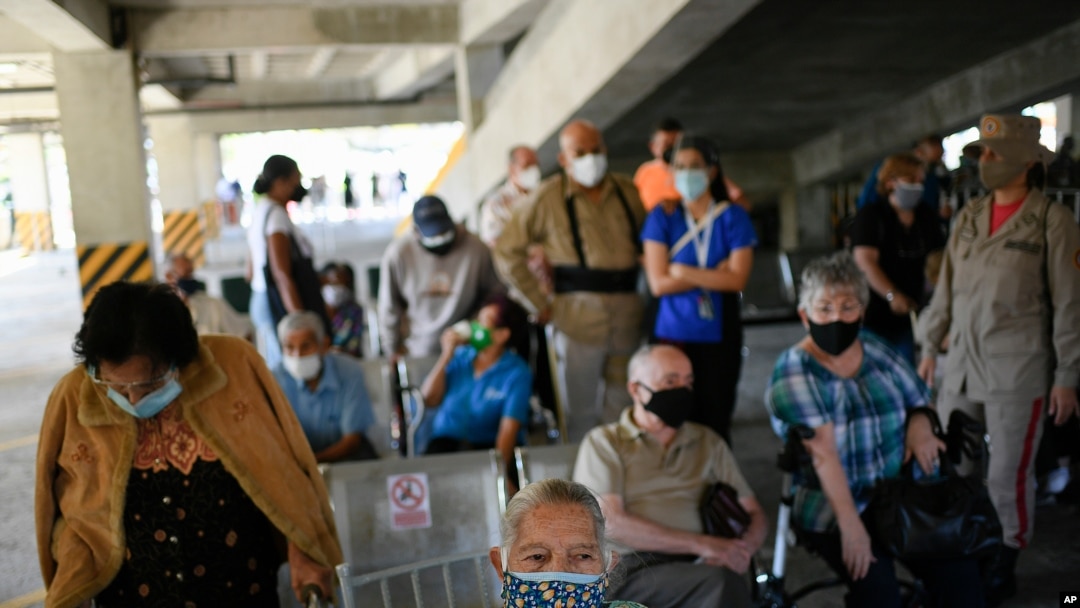 Personas esperan la vacuna Sputnik V para el COVID-19 en un centro de vacunación instalado en el estacionamiento del Instituto de Previsión Social de las Fuerzas Armadas (IPSFA) en Caracas. Junio 7, 2021.