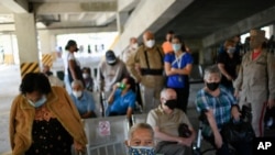 Personas esperan la vacuna Sputnik V para el COVID-19 en un centro de vacunación instalado en el estacionamiento del Instituto de Previsión Social de las Fuerzas Armadas (IPSFA) en Caracas. Junio 7, 2021.