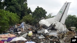 FILE - Responders pick through the wreckage of a cargo plane which crashed in the capital Juba, South Sudan Wednesday, Nov. 4, 2015. (AP Photo/Jason Patinkin)