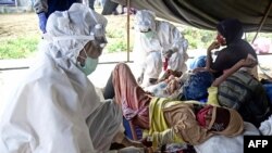 Seorang petugas medis (kiri) memeriksa pengungsi Rohingya di Lhokseumawe, Aceh, 7 September 2020. (Foto: Rahmat Mirza / AFP)