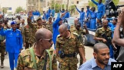 FILE - A handout image posted on the Sudanese Armed Forces's facebook page on August 31, 2023, shows army chief General Abdel Fattah al-Burhan (2nd L) waving as he walks among other army members and the media during a tour of a neighbourhood in Port Sudan.