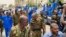 FILE - A handout image posted on the Sudanese Armed Forces's facebook page on August 31, 2023, shows army chief General Abdel Fattah al-Burhan (2nd L) waving as he walks among other army members and the media during a tour of a neighbourhood in Port Sudan.