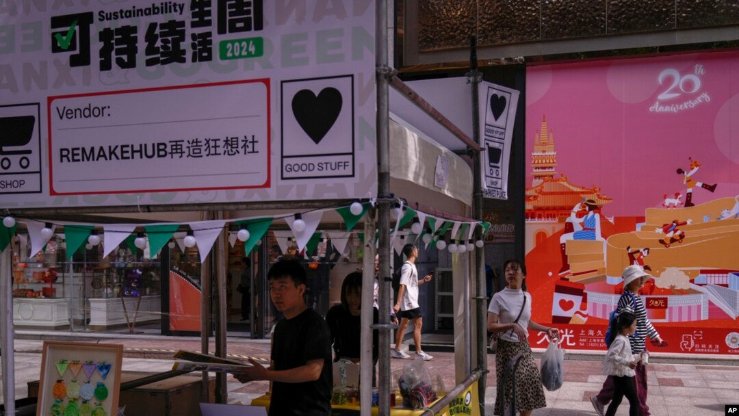 People walk by as vendors set up their stores at a popular shopping district in Shanghai on Oct. 12, 2024.