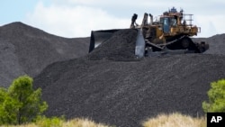 Heavy machinery moves coal at a mine near Muswellbrook in the Hunter Valley, Australia, Tuesday, Nov. 2, 2021.