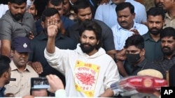 Indian actor Allu Arjun greets his fans in Hyderabad, India, Dec. 13, 2024, as he leaves a hospital where he was taken for medical checkup by policemen before arresting him after his appearance at a film screening allegedly led to a crush of fans in which a woman died. 