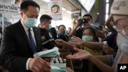 Menteri Kesehatan Thailand Anutin Charnvirakul,
membagi-bagikan masker dan mempromosikan kesadaran akan langkah pencegahan virus korona kepada warga di sebuah stasiun kereta api di Bangkok, Thailand (foto: dok).