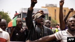 FILE - People take part in a march called by the opposition to protest the worsening security situation and ask for a response to jihadist attacks, in Ouagadougou, Burkina Faso, July 3, 2021.