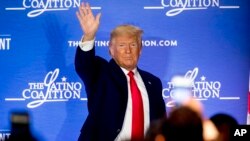 President Donald Trump waves after speaking at the Latino Coalition Legislative Summit, March 4, 2020, in Washington.