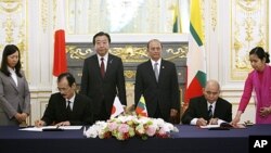 Japan's Ambassador to Burma Takashi Saito, seated left, and Burma's Ambassador to Japan Khin Maung Ting sign documents on their accord on the sidelines of the Mekong-Japan Summit at the State Guest House in Tokyo, April 21, 2012.