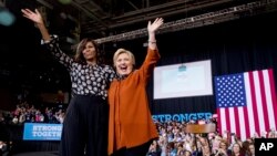 First lady Michelle Obama and Democratic presidential candidate Hillary Clinton wave together after speaking at a campaign rally at Wake Forest University in Winston-Salem, N.C., Oct. 27, 2016.