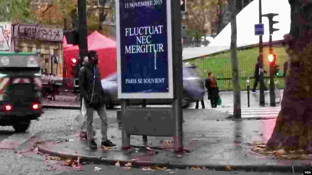 The ancient Paris motto, Fluctuat Nec Mergitur ('tossed but not sunk') surged in popularity after last year's attacks. One was on display on a street in Paris, Nov. 13, 2016. (L. Bryant/VOA)