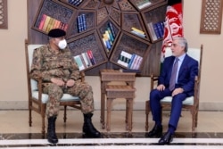 FILE - Abdullah Abdullah, chairman of the Afghan High Council for National Reconciliation, right, meets with Pakistan's Army Chief of Staff Gen. Qamar Javed Bajwa, in Kabul, Afghanistan, May 10, 2021.