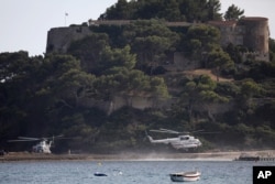 Russian President Vladimir Putin's helicopter, right, lands at the Fort de Bregancon before his meeting with French President Emmanuel Macron, Aug.19, 2019 in Bormes-les-Mimosas, southern France.