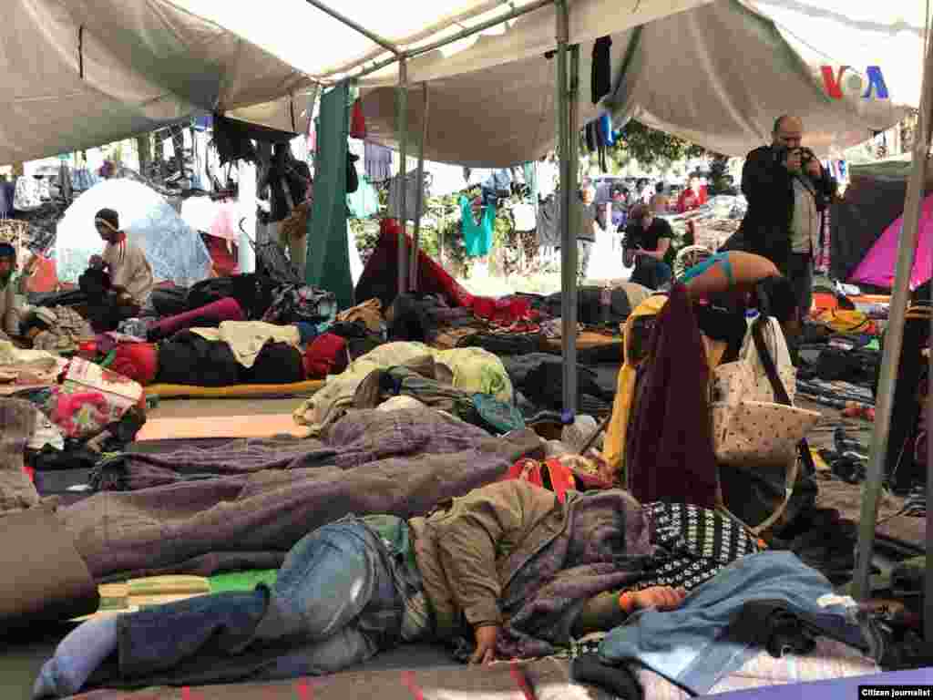 La gente descansa en el piso en un albergue en Tijuana, donde están a la espera de poder entrar a territorio estadounidense.&nbsp; Fotografía: Celia Mendoza- VOA