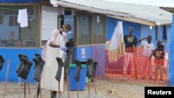 Boys stand in the "red zone" where they are being treated for Ebola at the Bong County Ebola treatment unit about 160 miles east of Monrovia, Liberia, in this Oct. 28, 2014, file photo. 