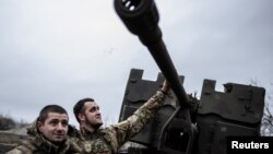 Service members of Ukrainian Joint Assault Brigade Fury stand next to an S60 cannon near the front-line town of Bakhmut, amid Russia's attack on Ukraine, in Donetsk region, Ukraine, on Dec. 21, 2023.