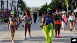 지난 24일 미국 플로리다주 마이애미비치에서 마스크를 쓴 관광객들.