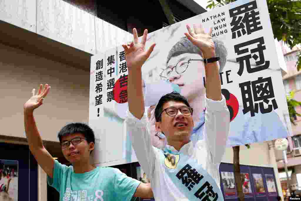 Nathan Law, (R), candidate from Demosisto and student activist Joshua Wong greet supporters on election day for the Legislative Council in Hong Kong, China.