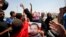 A supporter of former president Hosni Mubarak holds his poster to celebrate as she waits for his release in front of the main gate of Tora prison on the outskirts of Cairo, August 22, 2013. 