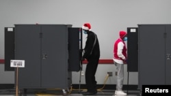 FILE - People cast their ballots in the U.S. Senate runoff elections on the first day of early voting in Atlanta, Georgia, Dec. 14, 2020.