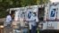 Postal workers load packages in their mail delivery vehicles at the Panorama city post office on Aug. 20, 2020 in the Panorama City section of Los Angeles.