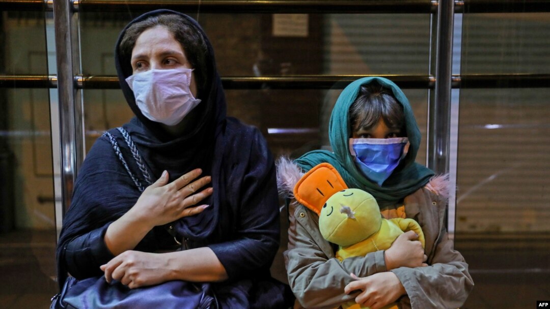 Iranians wearing face masks to protect against the coronavirus gather outside their buildings after an earthquake was felt in the capital Tehran, May 7, 2020. 