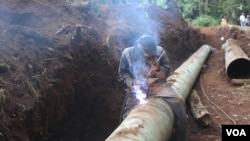 Nairobi City Water & Sewerage Company workers fix one of the water pipes in Central Kenya. The water pipes were destroyed in a landslide in April. (Mohammed Yusuf/VOA)