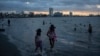 FILE - A woman and a girl walk along the shore to cool off during a heat wave on the coast of Veracruz, Mexico, on June 15, 2024. 