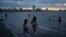 FILE - A woman and a girl walk along the shore to cool off during a heat wave on the coast of Veracruz, Mexico, on June 15, 2024. 
