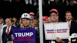 Delegates hold signs during the Republican National Convention Monday, July 15, 2024, in Milwaukee.